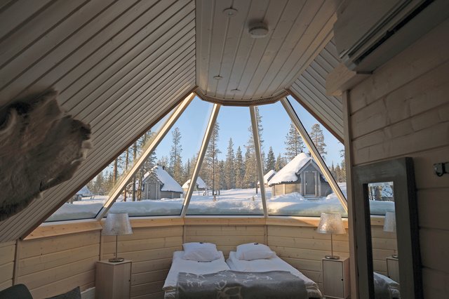 ガラスイグルーの室内。ガラス屋根の向こうに雪の森が見える