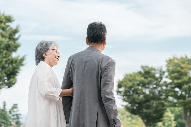 公園を歩くシニア夫婦(後ろ姿)